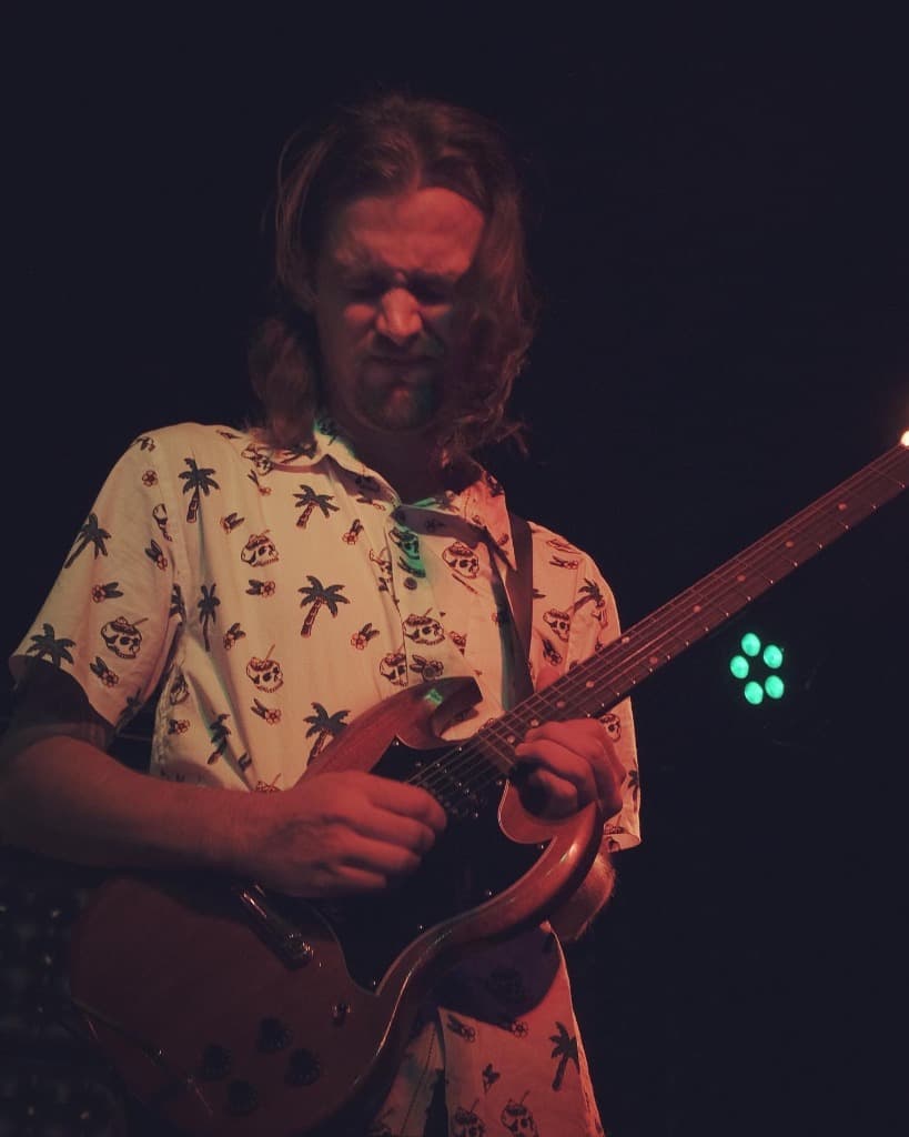 Luke Moore playing electric guitar solo on stage